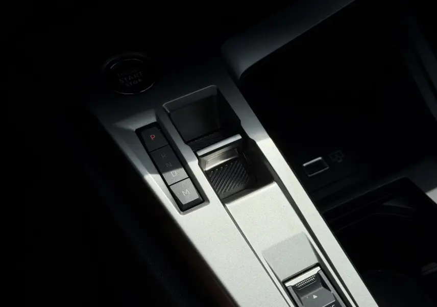 Gros plan sur la console centrale argentée avec sélecteur de boîte auto et bouton start du Peugeot 308 Hybrid 2025.