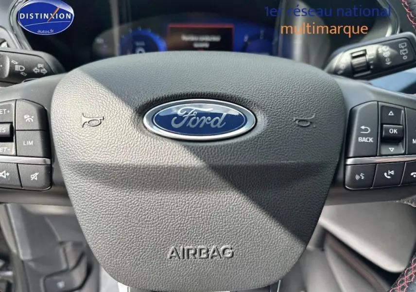Gros plan sur le volant noir du Ford Kuga 2022 avec logo central et commandes intégrées de chaque côté.