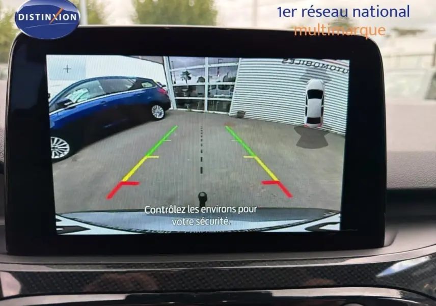 Écran tactile intérieur montrant la caméra de recul du Ford Kuga gris foncé avec lignes de guidage colorées.