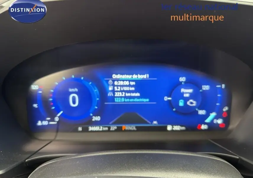Vue rapprochée du tableau de bord numérique bleu du Ford Kuga gris foncé, affichant vitesse et informations de bord.