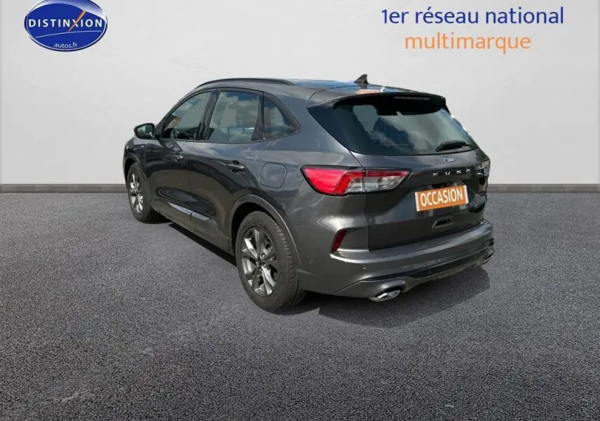 Vue 3/4 arrière droite d’un Ford Kuga gris foncé 2022 avec jantes alliage 18 pouces et attelage fixe visible.