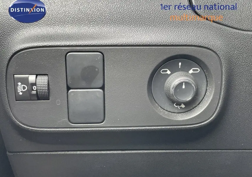 Gros plan sur les commandes de réglage des rétroviseurs et du niveau des phares dans une Citroën C3 gris Artense.