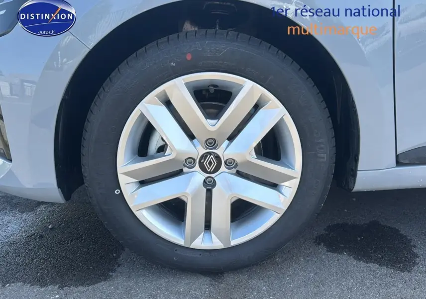 Gros plan sur la roue avant gauche d'une Renault Clio V gris rafale avec jante alliage 16 pouces et logo Renault central.