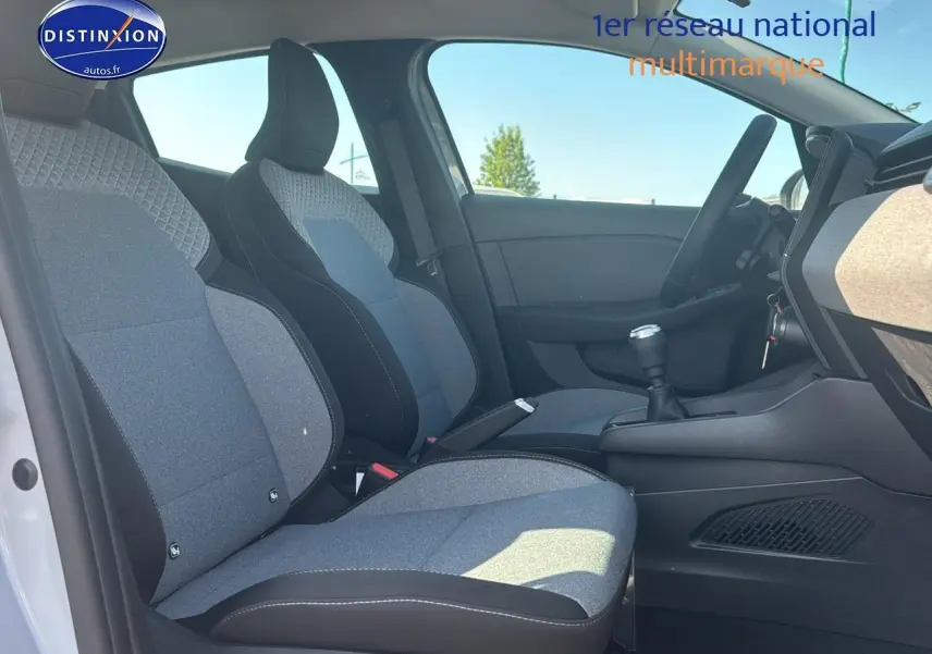 Vue intérieure côté conducteur de la Renault Clio V 1.5 dCi 100 gris rafale, sièges tissu gris et volant cuir.