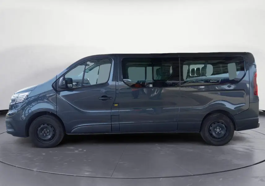 Renault Trafic Combi gris foncé métal vu de profil côté gauche, grand fourgon 9 places avec vitres teintées.