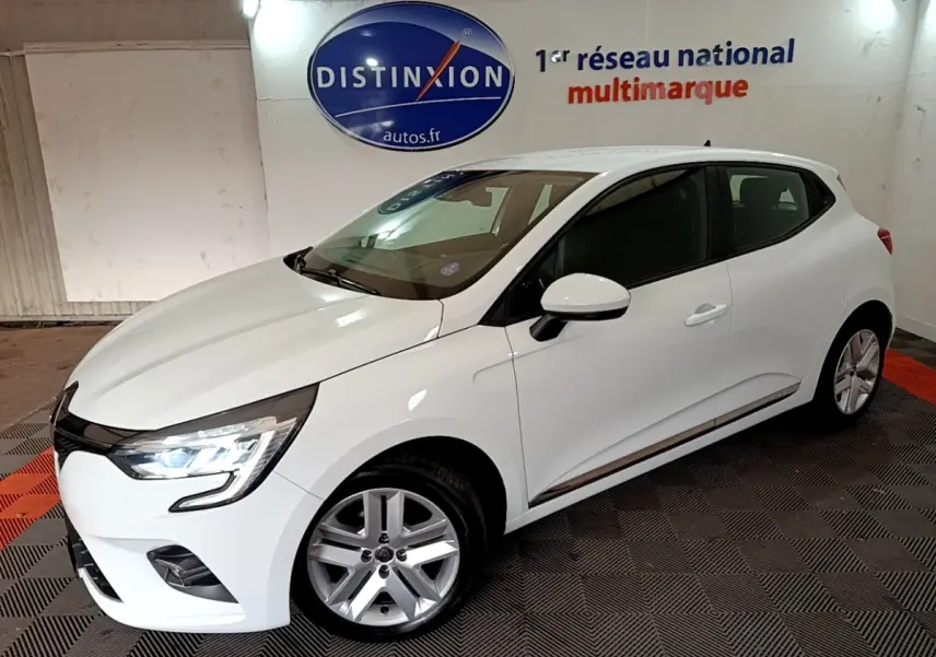 Renault Clio Business TCe 100 blanc vue 3/4 avant droit avec phares LED allumés en intérieur showroom