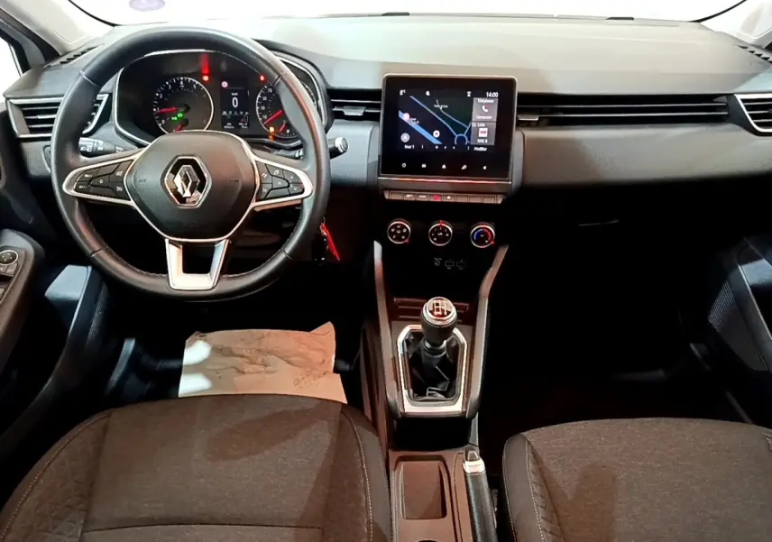 Vue frontale de l'habitacle de la Renault Clio Business TCe 100 2019 avec volant cuir, écran tactile et levier de vitesses manuel.