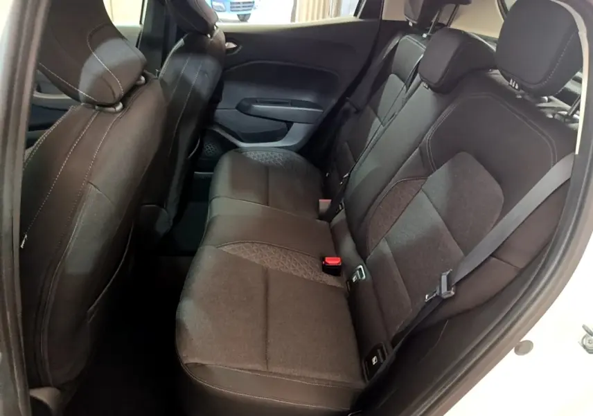 Vue intérieure des sièges arrière noirs d'une Renault Clio Business TCe 100 blanche, côté droit ouvert.