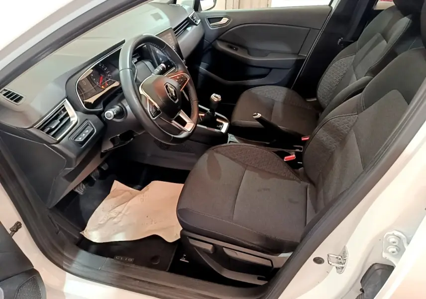 Intérieur avant droit d'une Renault Clio Business TCe 100 blanche, sièges tissu noirs et volant multifonctions cuir.