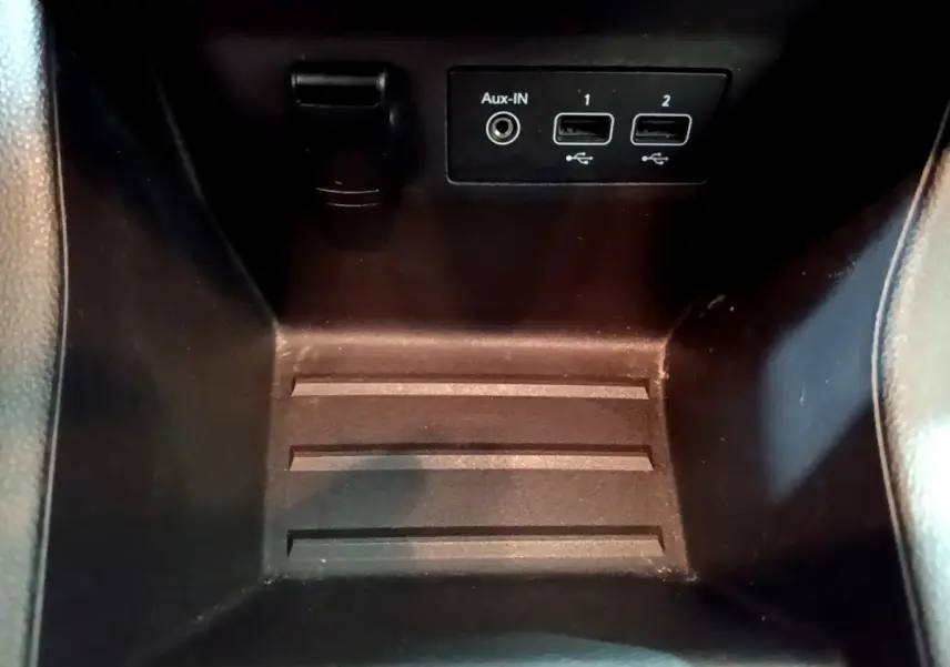 Gros plan sur la console centrale noire de la Renault Clio Business TCe 100 avec ports USB et entrée Aux-In visibles.