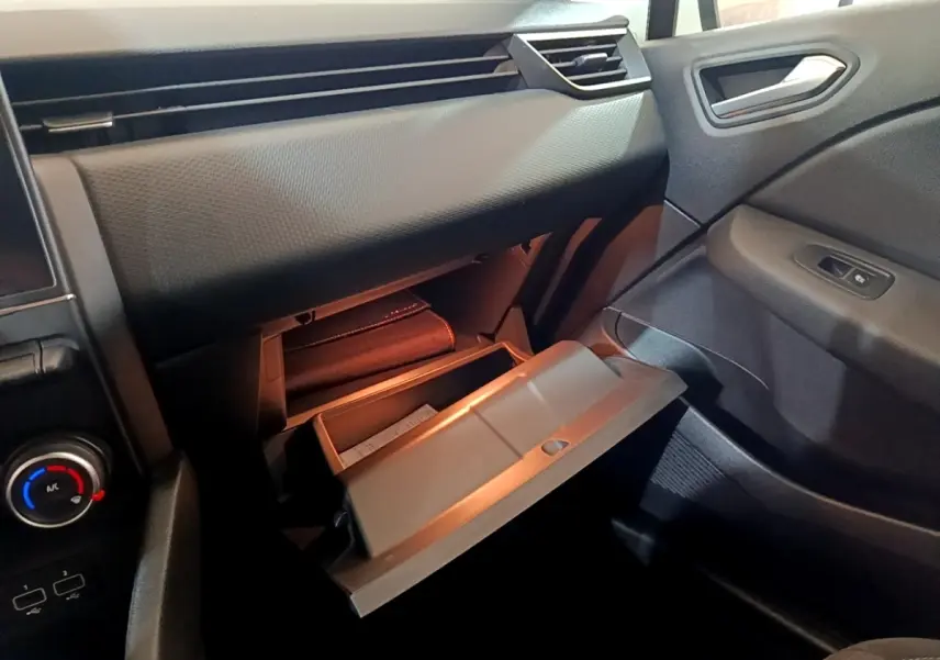 Intérieur de la Renault Clio Business TCe 100 2019, vue sur la boîte à gants ouverte côté passager, tableau de bord noir.