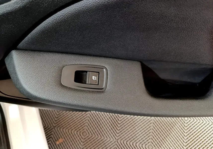 Gros plan sur le bouton de verrouillage centralisé dans la portière côté conducteur d'une Renault Clio blanche 2019.