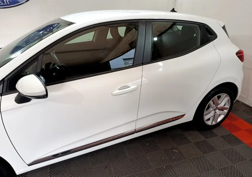 Profil côté gauche de la Renault Clio Business TCe 100 blanche, avec jantes alliage et poignées de porte assorties.