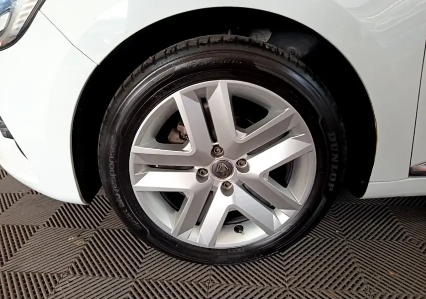 Gros plan sur la roue avant gauche blanche d'une Renault Clio Business TCe 100 de 2019 avec jante alliage argentée.