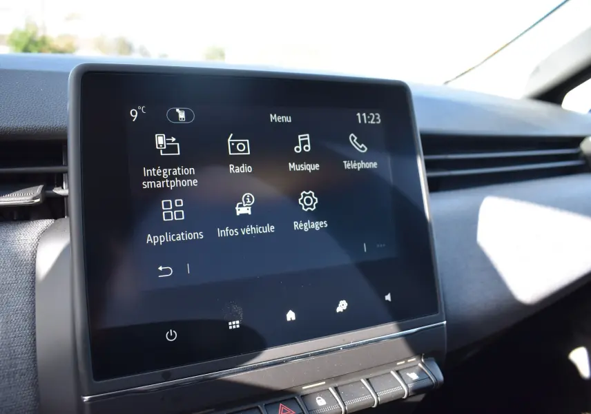 Écran tactile central du tableau de bord de la Renault Clio V noir, affichant le menu multimédia et réglages.