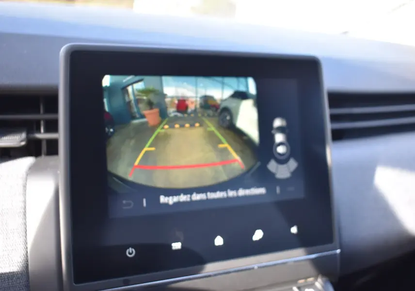 Écran central affichant la caméra de recul de la Renault Clio V noire, vue intérieure du tableau de bord.