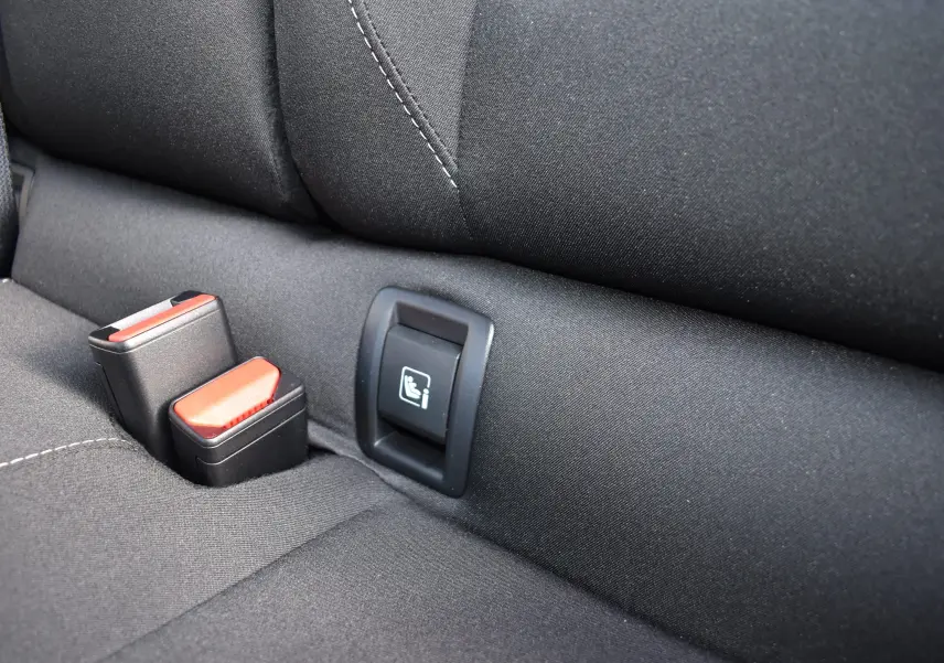 Gros plan sur la banquette arrière noire de la Renault Clio V, montrant les attaches ISOFIX et les boucles de ceinture.