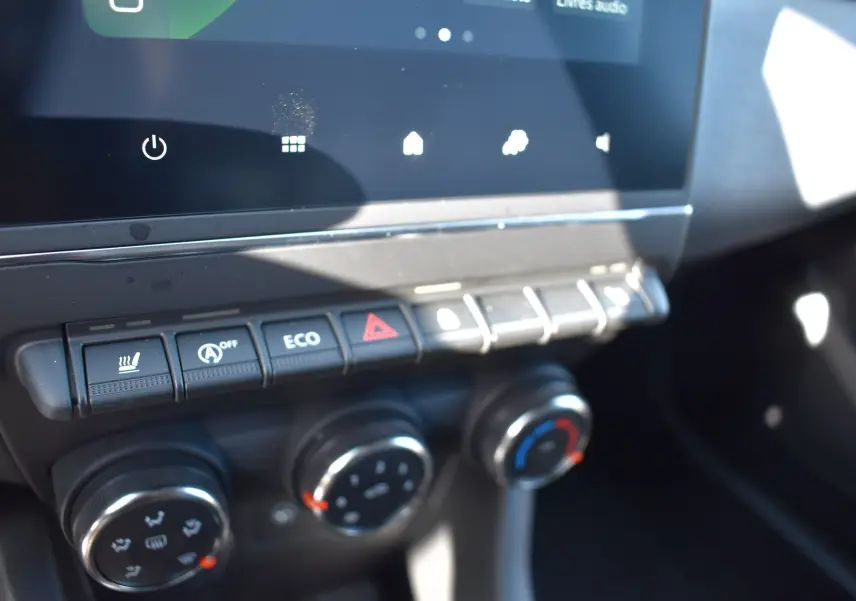 Détail du tableau de bord de la Renault Clio V TCE 90 noir, montrant les commandes de climatisation et les boutons de fonction.