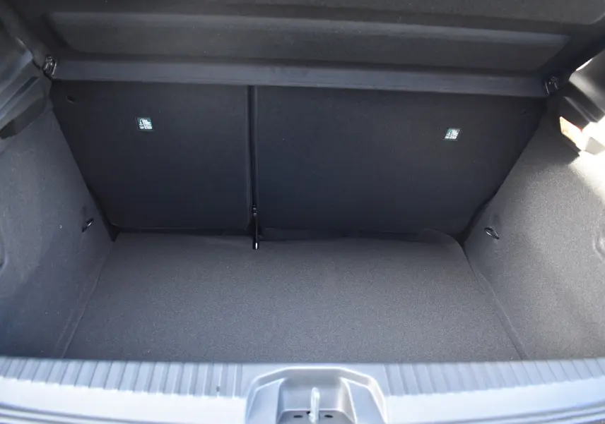 Coffre vide vu de face d'une Renault Clio V noire, montrant l'espace de rangement et la finition intérieure en tissu noir.