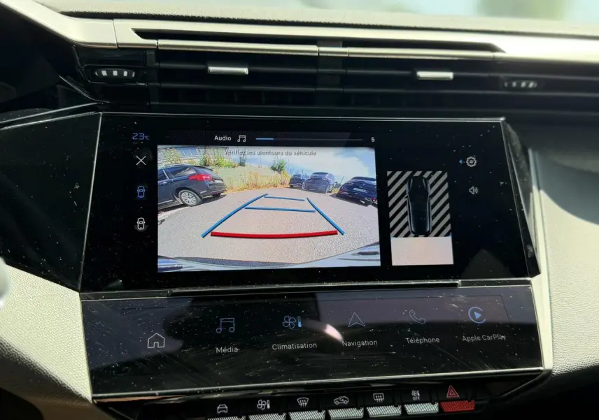 Écran tactile central de la Peugeot 308 Hybrid 2025 montrant la caméra de recul et l’aide au stationnement.
