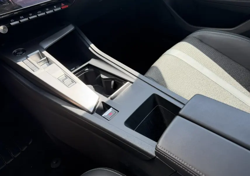 Détail de la console centrale et siège avant droit gris clair de la Peugeot 308 Hybrid 2025 finition Allure.