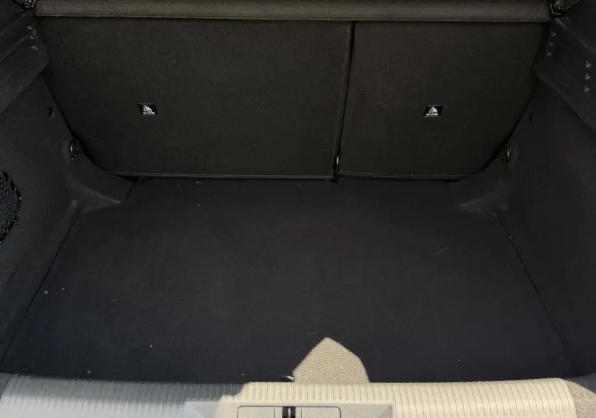 Vue intérieure du coffre noir spacieux de la Peugeot 308 Hybrid 145 e-DSC6 Allure gris Artense, sans chargement visible.
