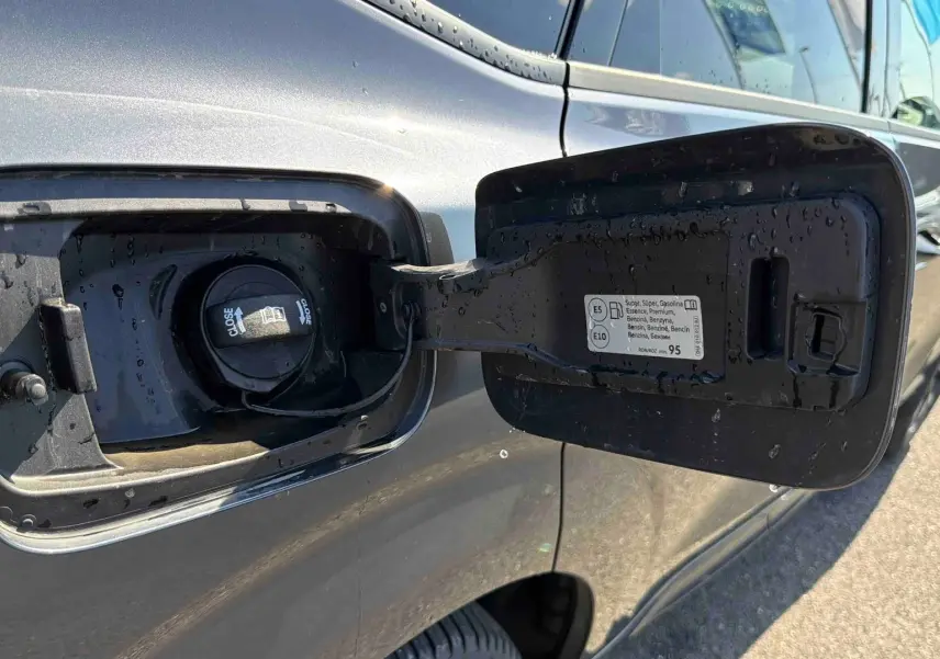Bouchon de réservoir essence ouvert sur la partie arrière gauche d'une CUPRA TERRAMAR grise sous la lumière du jour.