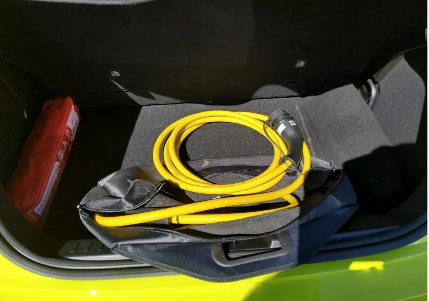 Coffre ouvert vu de dessus d’une FIAT 500 électrique jaune Acid avec câble de recharge jaune enroulé.