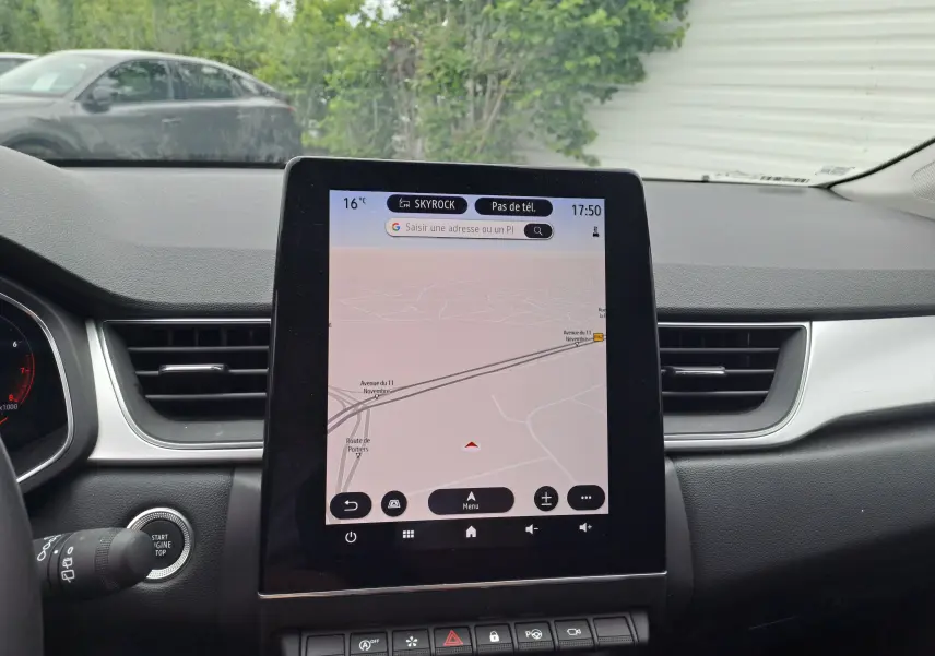 Vue intérieure du tableau de bord du Renault Captur 2024 avec écran tactile central affichant la navigation GPS.
