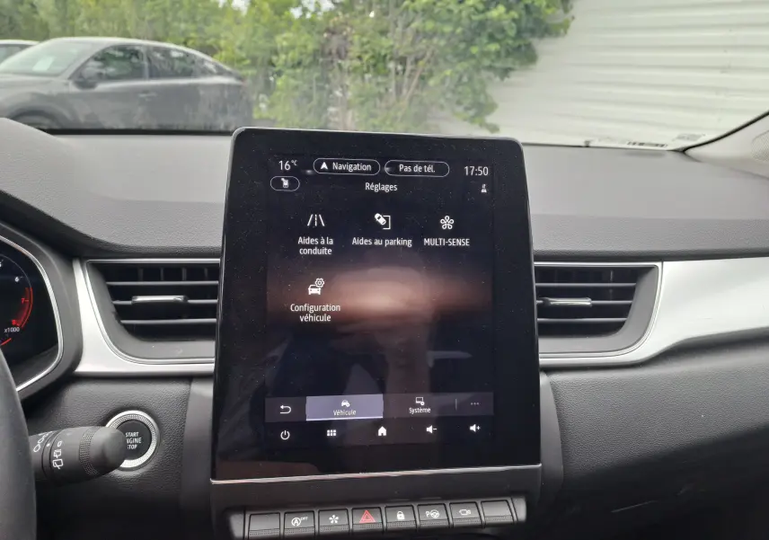 Écran tactile central du tableau de bord du Renault Captur 2024 affichant les réglages d'aides à la conduite, vue intérieure.