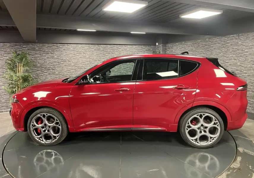 Profil droit de l'Alfa Romeo Tonale rouge 2024 avec jantes 20 pouces et étriers de frein rouges visibles.