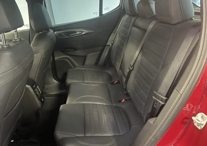 Vue intérieure côté droit sur la banquette arrière en cuir noir avec surpiqûres rouges d'une Alfa Romeo Tonale rouge 2024.