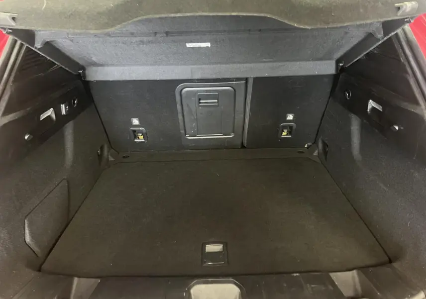 Coffre ouvert de l'Alfa Romeo Tonale rouge 2024, montrant l'espace de chargement intérieur noir.