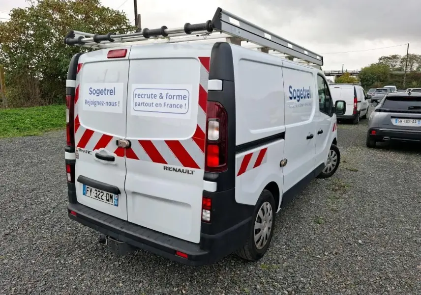 Renault Trafic Fourgon blanc vu en 3/4 arrière droit avec marquages rouges et logo Sogetrel sur les portes arrière et latérales.
