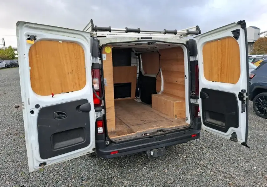 Vue arrière ouverte du Renault Trafic Fourgon blanc 2021 avec aménagement intérieur en bois visible.
