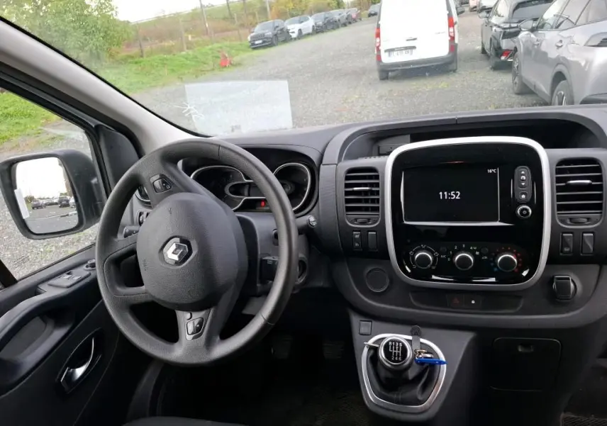 Vue intérieure du poste de conduite du Renault Trafic Fourgon blanc 2021, volant multifonction et écran central tactile.