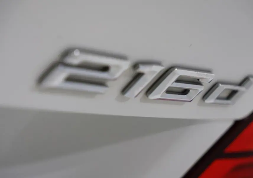 Gros plan sur l’inscription 216d en chrome sur la partie arrière blanche d’une BMW Série 2 Active Tourer.