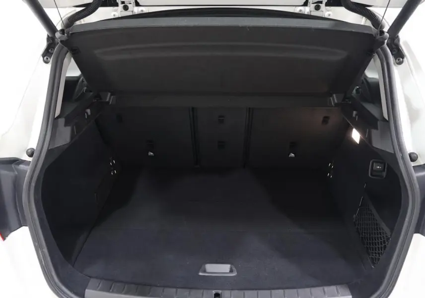 Coffre arrière ouvert d'une BMW Série 2 Active Tourer blanche, vue de face montrant l'espace de chargement vide et propre.