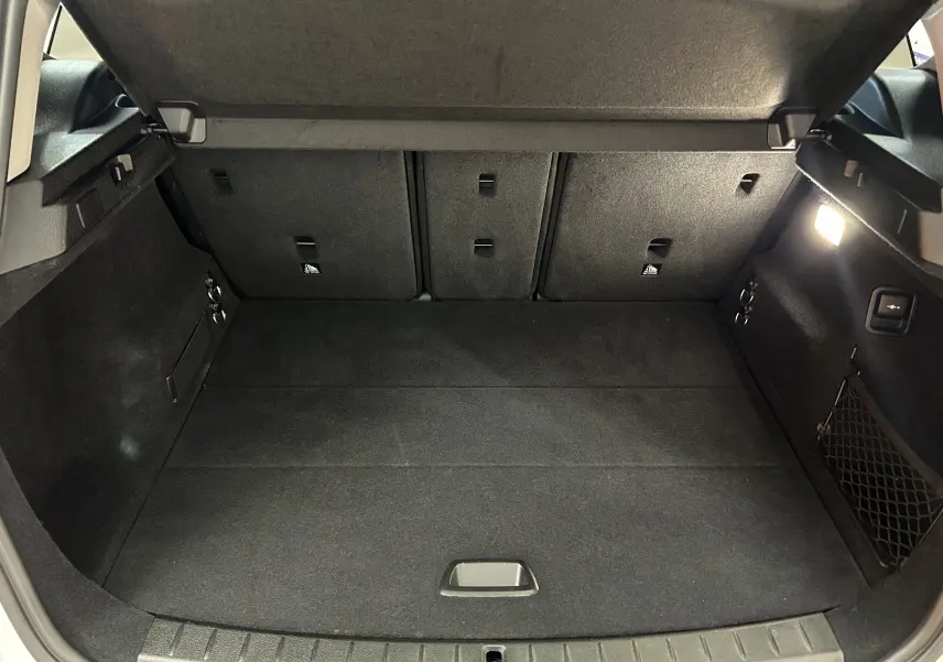 Coffre ouvert vu de l'arrière d'une BMW Série 2 Active Tourer blanche, espace de chargement propre et bien éclairé.