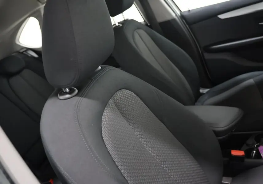 Gros plan sur les sièges avant en tissu gris foncé de la BMW Série 2 Active Tourer blanche, vue côté droit intérieur.