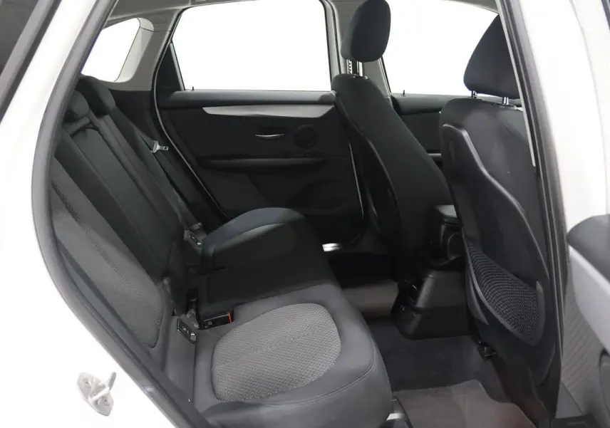 Vue intérieure côté gauche des sièges arrière noirs en tissu d'une BMW Série 2 Active Tourer blanche, version 216d.