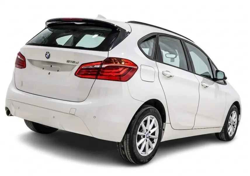 Vue 3/4 arrière droite d'une BMW Série 2 Active Tourer 216d blanche avec feux arrière LED et jantes alliage.