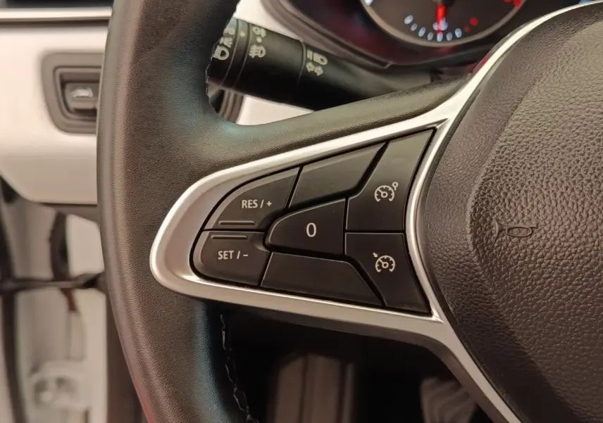 Gros plan sur le volant multifonctions noir de la Renault Clio Evolution TCe 100 GPL avec commandes de régulateur de vitesse.