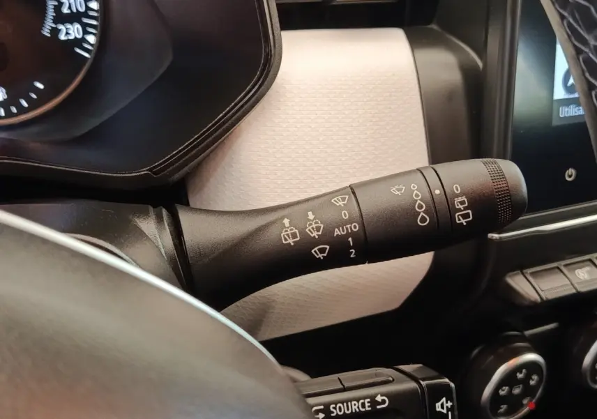 Gros plan sur la commande des essuie-glaces côté gauche du tableau de bord blanc de la Renault Clio Evolution TCe 100 GPL 2023.