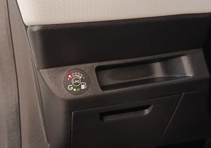 Gros plan sur le tableau de bord noir de la Renault Clio blanc, montrant l'indicateur de niveau GPL lumineux.