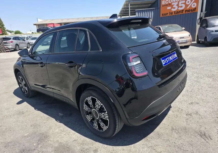 Vue 3/4 arrière droite d'une FIAT 600 noire 2025 avec jantes alliage et feux arrière LED distinctifs.