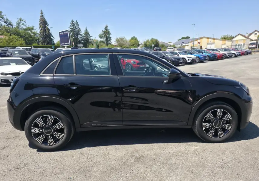Vue de profil côté gauche d'une FIAT 600 noire 2025 avec jantes alliage et coques de rétroviseurs noires brillantes.