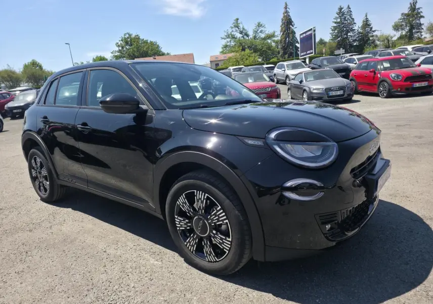 Vue 3/4 avant droite d'une FIAT 600 noire avec jantes alliage distinctives et phares LED arrondis.