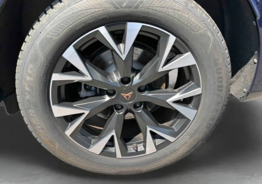 Gros plan sur la jante alliage gris anthracite à design géométrique du CUPRA Terramar bleu, avec logo CUPRA central cuivré.
