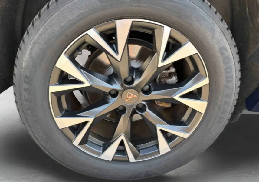 Gros plan sur la jante alliage 18 pouces au design géométrique bicolore avec logo CUPRA central, pneu Goodyear visible.